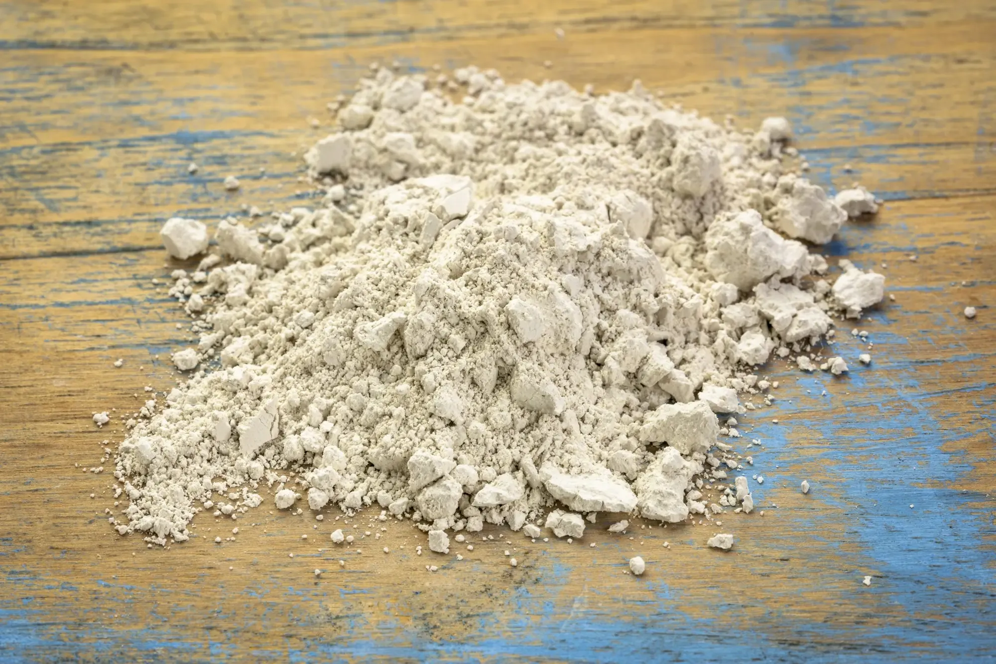 Fine diatomaceous earth powder on a wooden surface